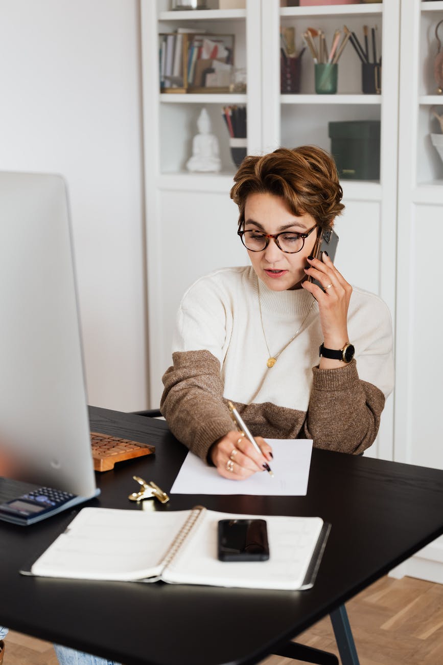 remote employee talking on phone and taking notes